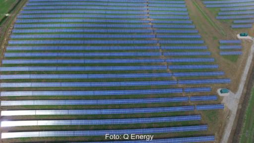 Luftbild von Solarmodul-Reihen auf grüner Wiese.