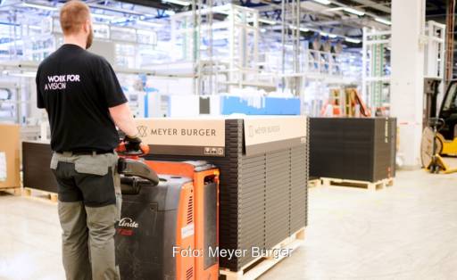 Im Bild ein Mann mit einer Palette von Meyer-Burger-Photovoltaikmodulen, Solaranlagen mit solchen Solarmodulen kann man jetzt über Otovo beziehen.
