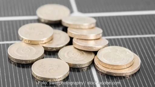 Münzen auf PV-Modul als Symbol für EEG-Konto und Strommarktreform.