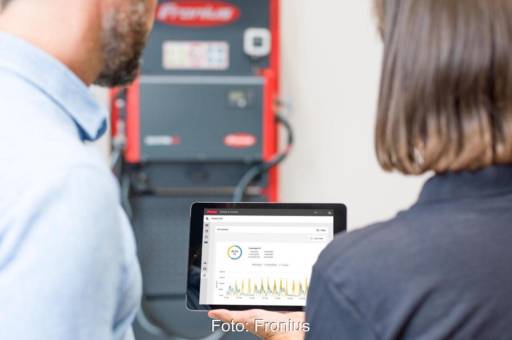 Im Bild sein Menschen, die auf ein Tabeltt schauen, das mit dem Charge &amp; Connect-Portal von Fronius Perfect Charging verbunden ist.