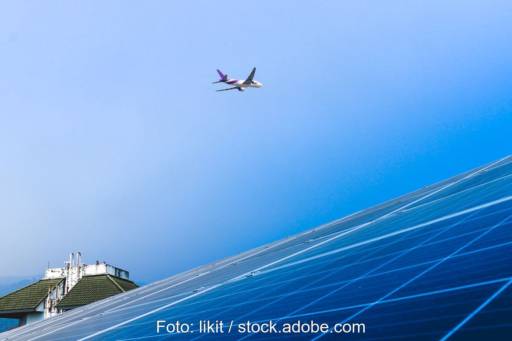 Ein Flugzeug fliegt über ein Dach hinweg, das aus Solarzellen besteht.