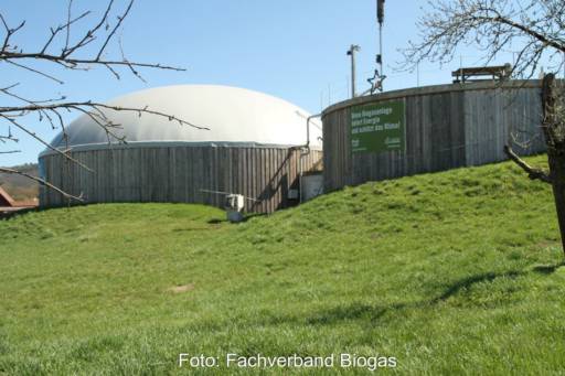 Fermenter einer Biogasanlage auf einem grünen Wiesenhügel.