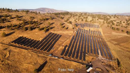 Luftaufnahme einer PV-Freiflächenanlage in einer trockenen Landschaft.