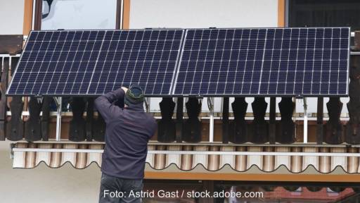 Zu sehen ist ein Mann, der ein Balkonkraftwerk installiert, dafür gibt nun Geld im Solarförderprogramm der Stadt Essen.