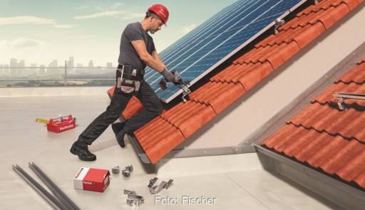 Im Bild ein Mann, der Photovoltaik-Montagesysteme von Fischer ausprobiert.