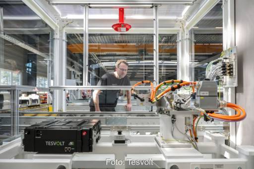 Mitarbeiter kontrolliert Batterien in automatisierter Fabrik.