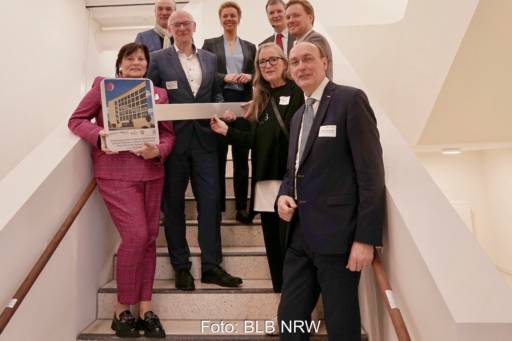 Gruppenfoto mit acht Menschen auf neuer Treppe - Einweihung am neuen Forschungszentrum für Batterie- und Leistungselektronik