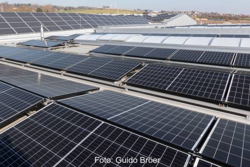 Photovoltaikanlage auf dem Dach einer gewerblich genutzten Halle, im Vordergrund mit flachen Gestellen in Ost-West-Ausrichtung
