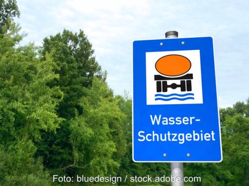 Ein Hinweisschild für ein Wasser-Schutzgebiet vor grünen Bäumen