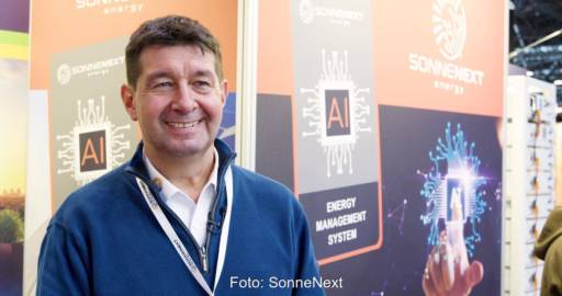 Portrait des SonneNext-Geschäftsführer Hans Jörg Hölzenbein vor einem Messestand.