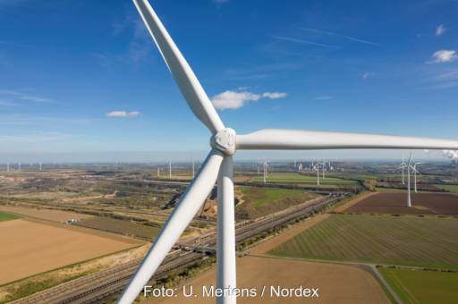 Blick auf die Nabe einer Windkraftanlage an Land. Im Hintergrund weitere Windkraftanlagen.