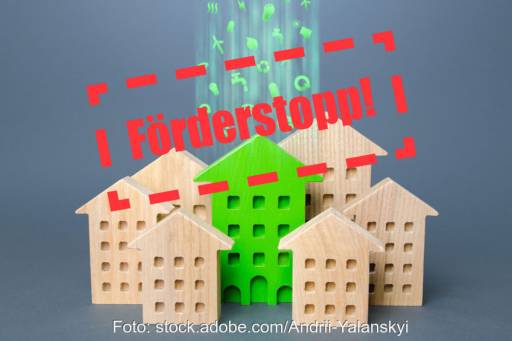 Bauklötze in Gebäudeform symbolisiere Grünes Gebäude - Stempel Förderstopp durchbricht die Szene. Symbol für Antragsstopp