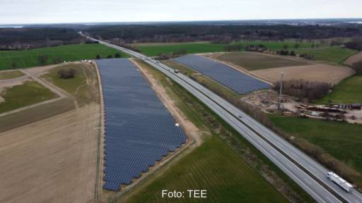 Luftbild eines PV-Parks zu beiden Seiten einer Autobahn.