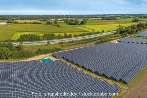 Panorame-Luftbild einer Photovoltaik-Freiflächenanlage an einer Autobahn, wie sie künftig nach § 35 BauGB im Außenbereich privilegiert sind.