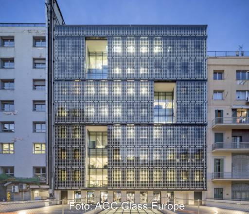 Eine Gewerbeimmobilien mit einer Fassade von durchlässigen Photovoltaikmodulen.