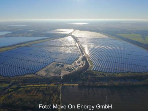 Luftbild eines 600 MW großen Solarparks bei tief stehender Sonne.