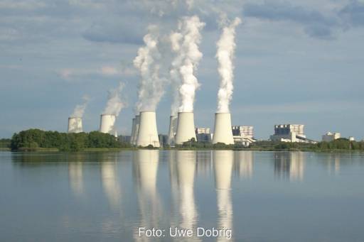 Blick über einen Binnensee auf Kühltürme eines Kraftwerks