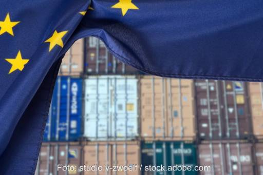 Container gestapelt, davor EU-Flagge, Symbol für Schutzmaßnahmen für Solarindustrie