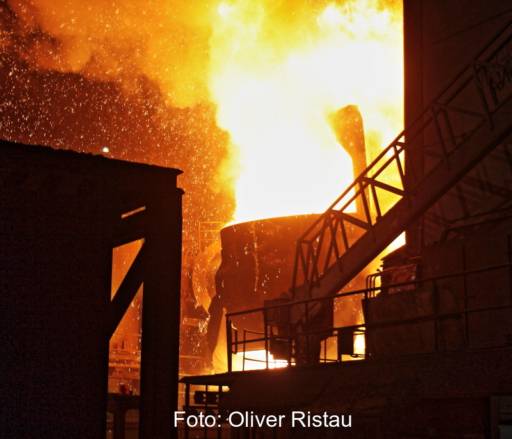 Ein Kessel mit glühendem Stahl im Stahlwerk, Funken sprühen