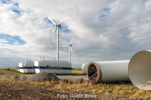 Repowering einer Windenergieanlage. Im Vordergrund Teile einer abgebauten Anlage. In Hintergrund steht bereits eine neue Windturbine.