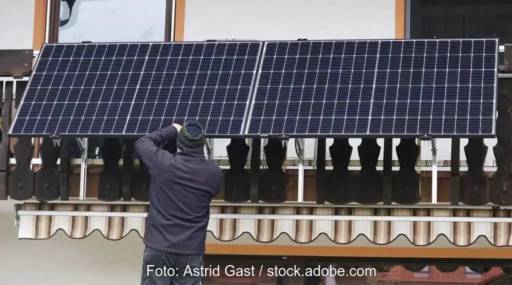 Im Bild ein Mann, der ein Balkonkraftwerk installiert, Vitapower ist ein Speichersystem für Balkonkraftwerke.