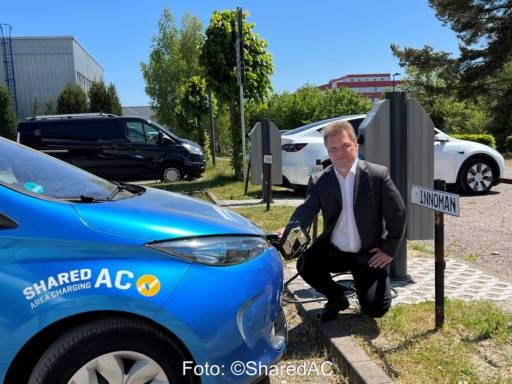 Ein Mann schließt ein E-Mobil an das Ladenetz an.