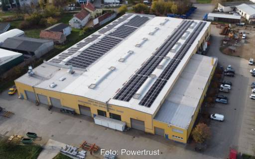 Luftbild eines Gewerbegebäudes mit PV-Anlage auf dem Dach.