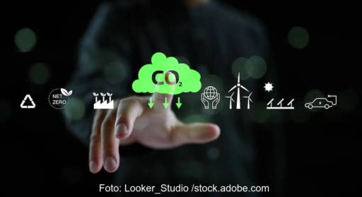 Im Bild eine Hand und Symbole und ein Pfeil CO2 runter, ob neues Klimaschutzgesetz die CO2-Einsparung befördert, ist umstritten.