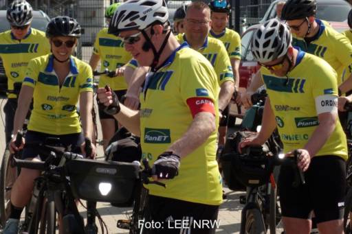 Eine Gruppe von Radfahrern mit gelben Fahrradtrikots.