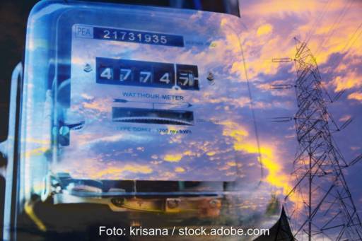 Foto durch Glas zeigt einen Stromzähler außerdem die Reflexion der Wolken und eines Strommastes.