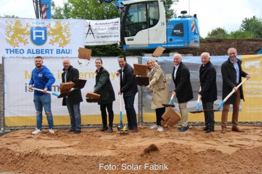 Acht Personen vollziehen gut gelaunt einen Spatenstich.