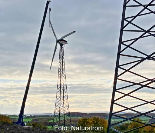 Ein Kran demontiert eine alte Windenergieanlage.