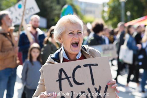 Frau protestiert mit-Pappschild auf einer Demonstration fuer Klimaschutz