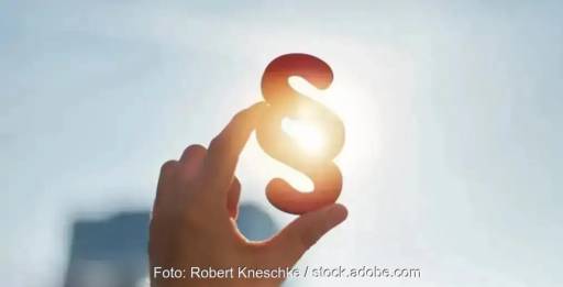 Im Bild ein Paragrafenzeichen, das eine Hand in die Sonne hält als Symbol für das Solarpaket I, das in Kraft getreten ist.