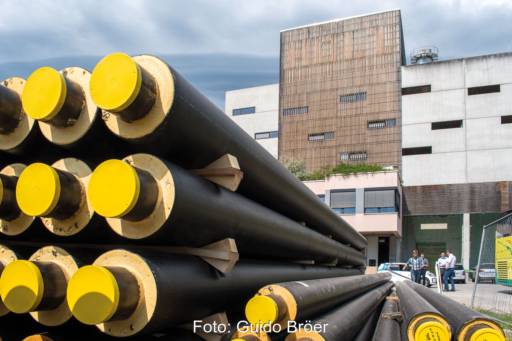 Stücke von Fernwärme-Leitungen liegen auf Stapel vor Gebäude - Symbolbild für neue Transparenz-Plattform.