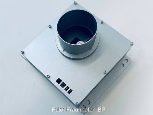 Metallisches Bauteil mit Rohrstutzen auf eckiger Grundplatte - Teil der neuen automatischen Kaminofen-Regelung.