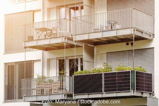 Vier Balkone an einem Haus, davon ist einer mit einer Steckersolaranlage ausgestattet.