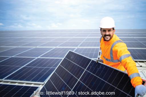 Ein Handwerker installiert ein Photovoltaikmodul für eine größere - gewerbliche - Anlage. Mieterstrom ist nun auch für das Gewerbe möglich.