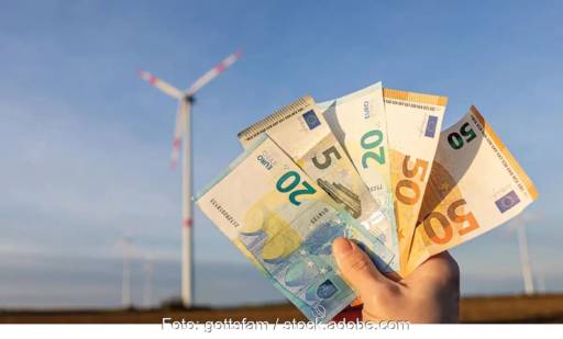 Im Bild Geldscheine vor Windenergieanlage, das Windenergieanlagenabgabegesetz Brandenburg legt eine Sonderabgabe für Windräder fest.