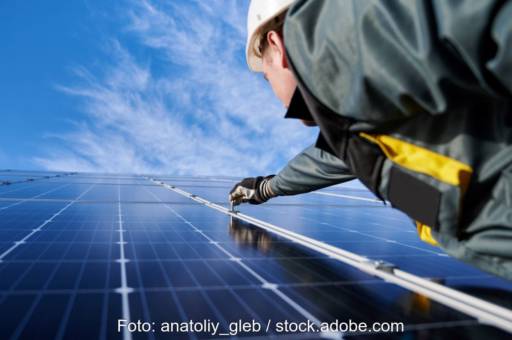 Ein Installateur montiert PV-Paneele.