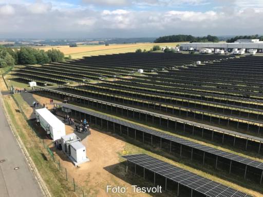 Vogelperspektive auf Photovoltaik-Großanlage und einen Container, in dem sich ein Batterie-Speicher befindet.