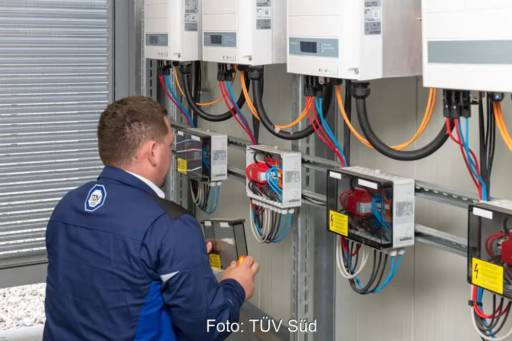 Im Bild ein Mann, der Wechselrichter einer Photovoltaik-Anlage prüft, TÜV Süd kooperiert mit der Zurich-Versicherung.