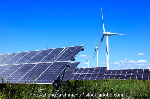 Freiflächen-Photovoltaikanlage vor Windenergieanlagen - Symbolbild für Beschleunigungsgebiete für beide Technologien