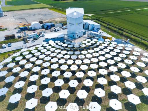 Luftbild zeigt mehrere Spiegel, die Sonnenlicht auf einen Turm konzentrieren.