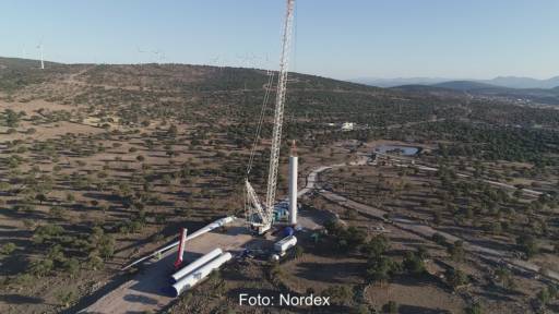 Karge Landschaft, Windenergie-Anlagen im Hintergrund, vorne eine Anlage im Aufbau - Nordex-Auftrag aus Spanien.
