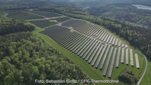 Luftbild eines Solarkomplexes umgeben von Wald.