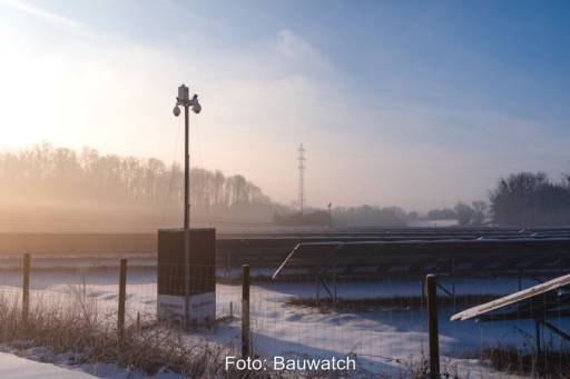 Mast mit energieautarker Überwachungskamera in einem Solarpark