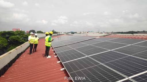 Im Bild Menschen auf dem Dach bei einer der Photovoltaik-Anlagen in Afrika.