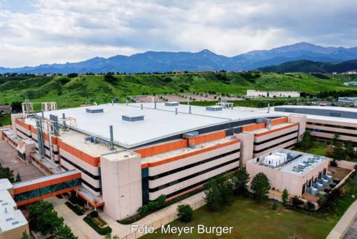 Fabrikgelände vor Bergkette am Horizont.