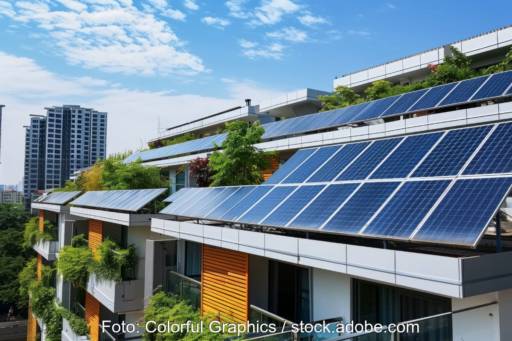 Neubau mit Photovoltaik und im Hintergrund Hochhäuser.